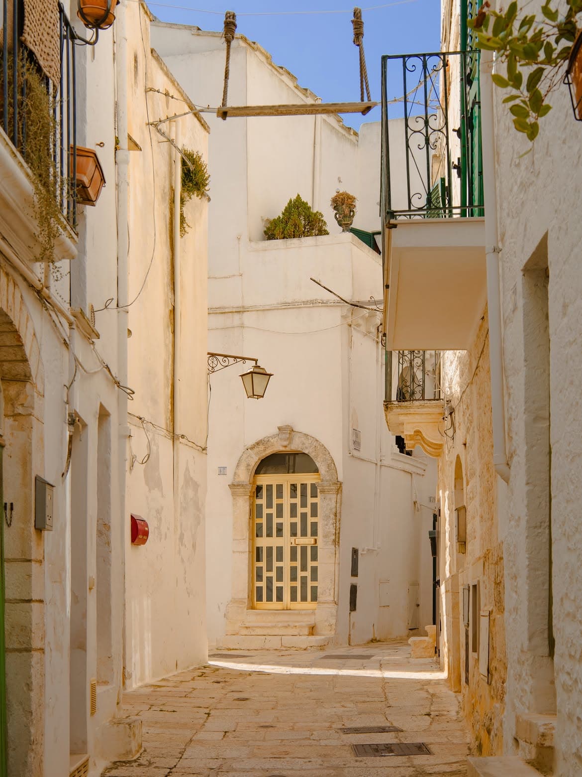 narrow whitewashed lane in Cisternino with arches, balconies, and stone steps
